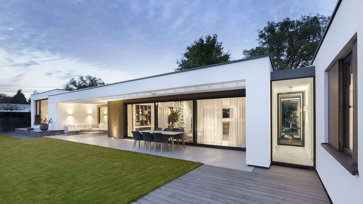 Witte bungalow met grote ramen en schuifpui